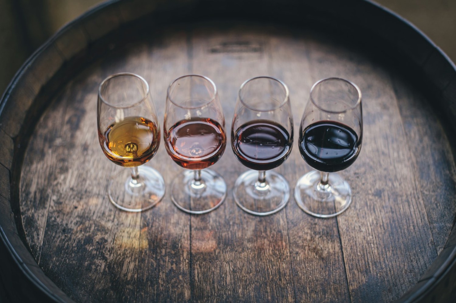 A flight of 4 wines on a barrel